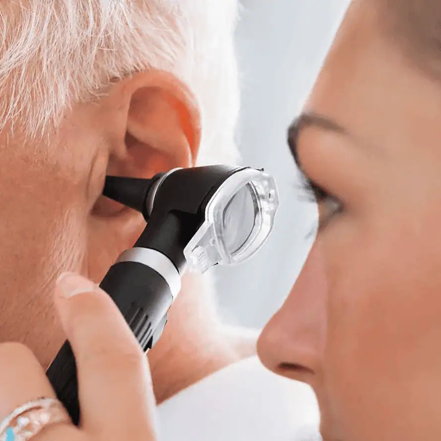 Hear Clear hearing specialist inspecting a patient's ear canal with a medical device for ear health assessment